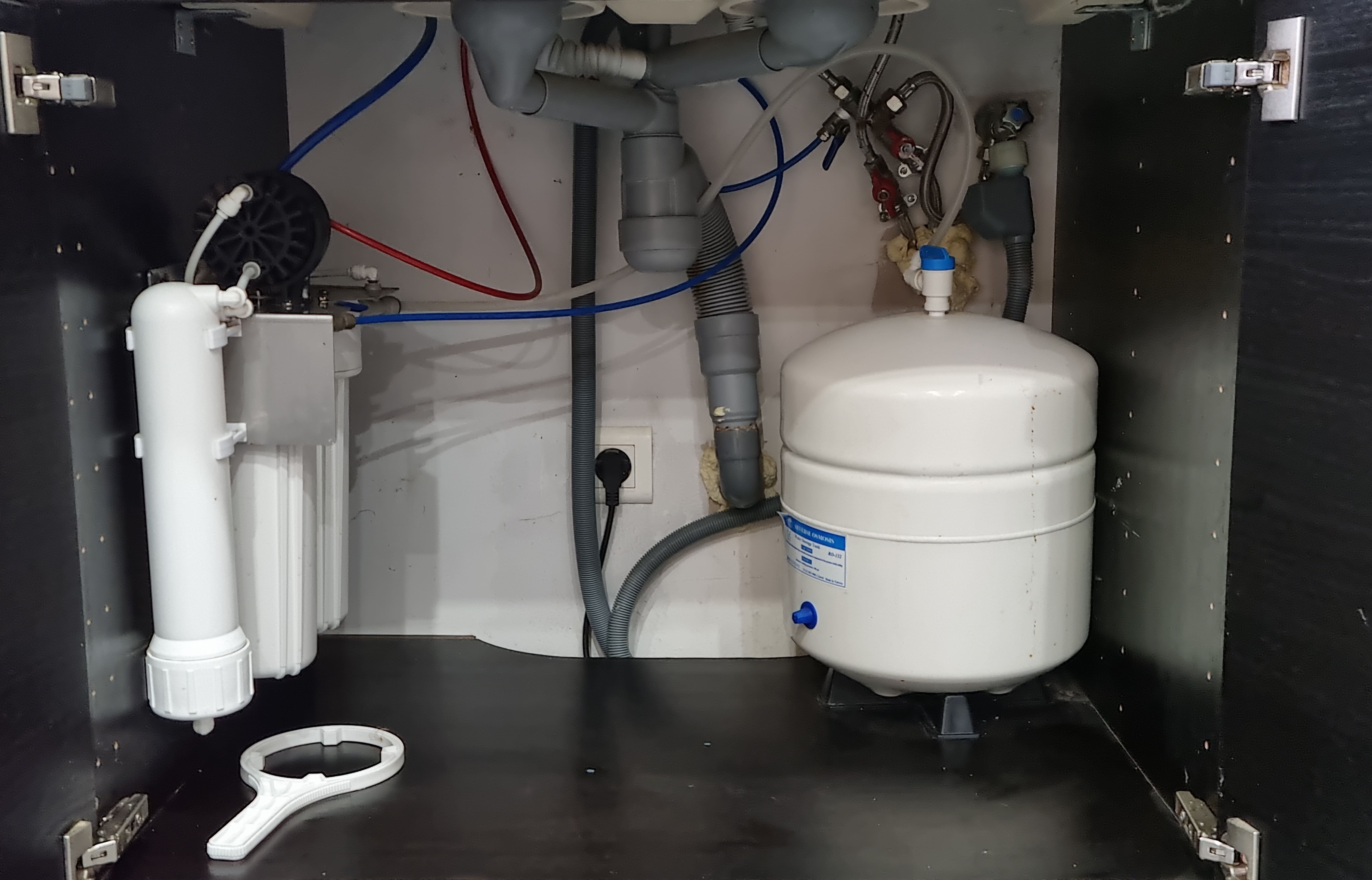 OSMOSEUR DOMESTIQUE SOUS EVIER INSTALLE. A GAUCHE LE MODULE DE FILTRATION AVEC LA MEMBRANE ET A DROITE LE RESERVOIR